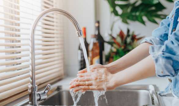 A person washing their hands in the sink.